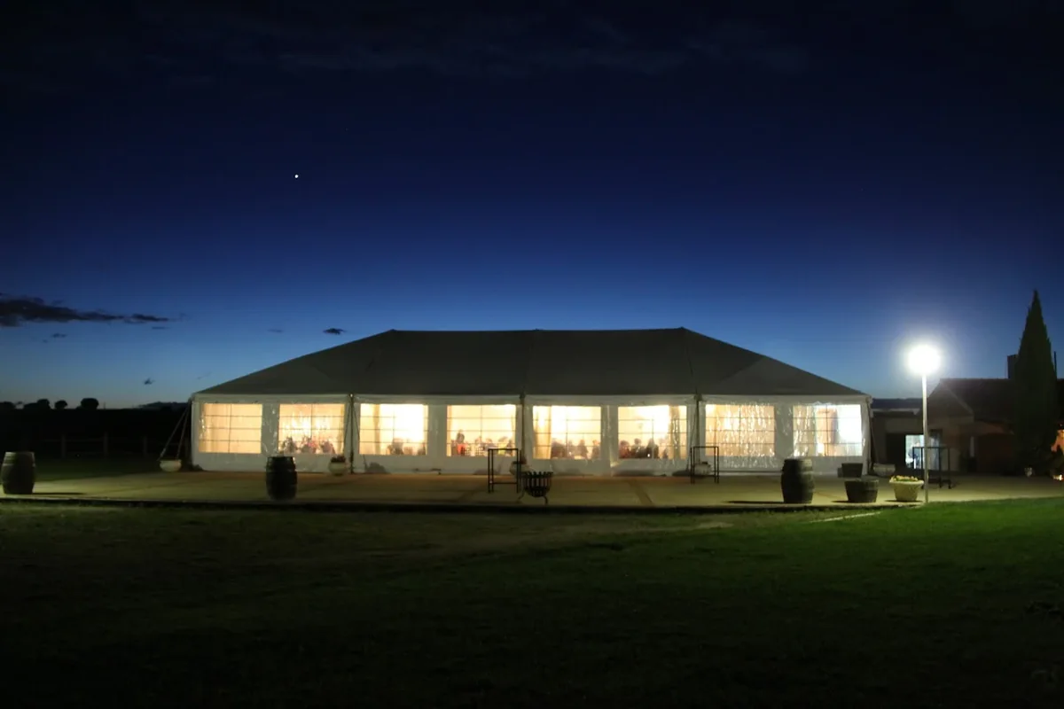 La carpa de noche vista desde el jardín
